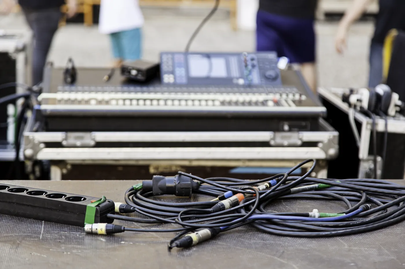 A mixing desk on flight cases, cabled up for a location recording