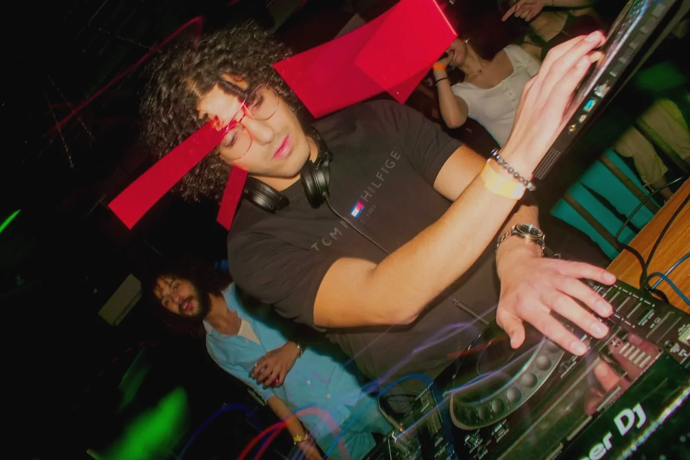 Anas working the decks under a red light streak