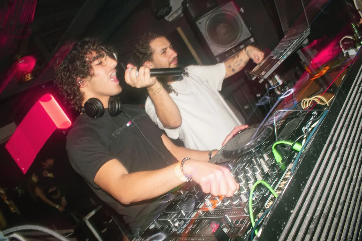 Anas on the microphone at the decks, with another DJ beside him